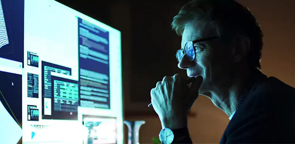 Man looking at a large monitor.